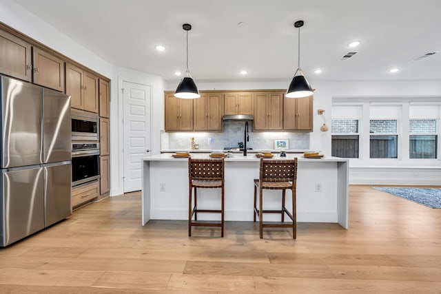 kitchen with visible vents, tasteful backsplash, appliances with stainless steel finishes, light wood finished floors, and light countertops