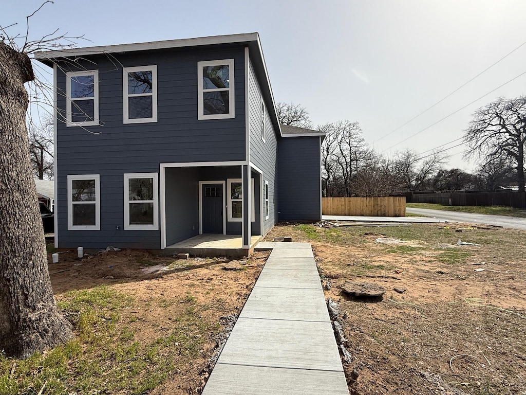 view of front of home featuring a patio area and fence