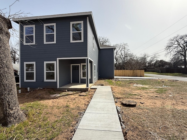 view of front of home featuring a patio area and fence