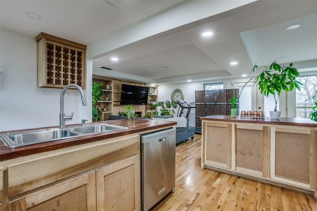 kitchen featuring dishwasher, light wood-style flooring, a sink, and wood counters