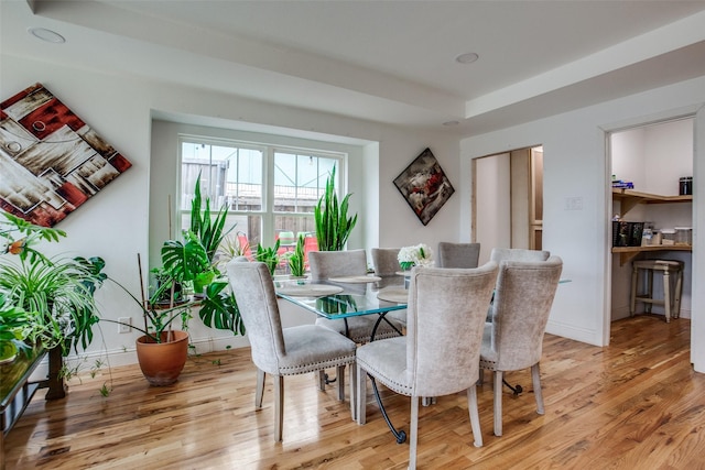 dining space with light wood-style flooring and baseboards