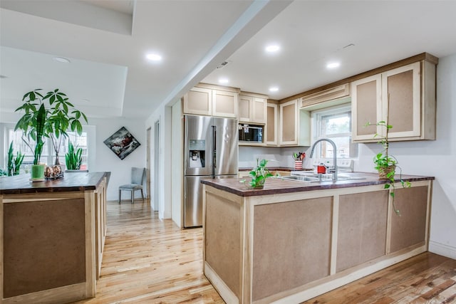 kitchen featuring appliances with stainless steel finishes, a peninsula, butcher block counters, and light wood finished floors