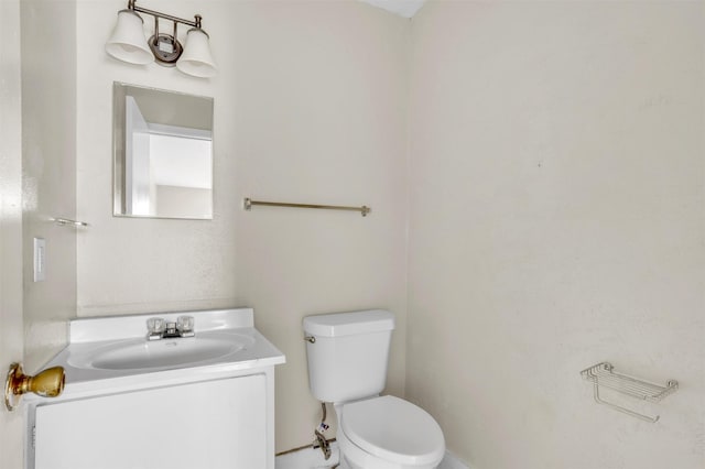 half bathroom with vanity and toilet