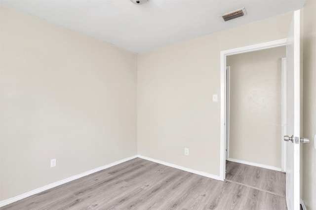 unfurnished room with baseboards, visible vents, and light wood finished floors