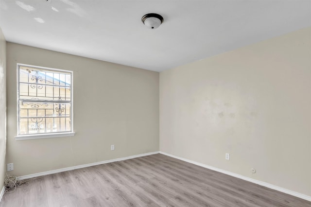 empty room with wood finished floors and baseboards