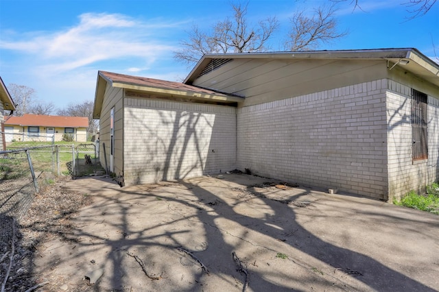 back of house with brick siding and fence