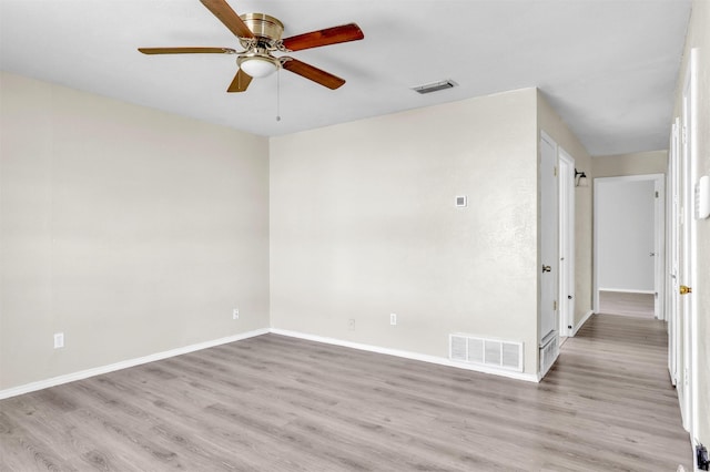 empty room with a ceiling fan, light wood-style floors, visible vents, and baseboards