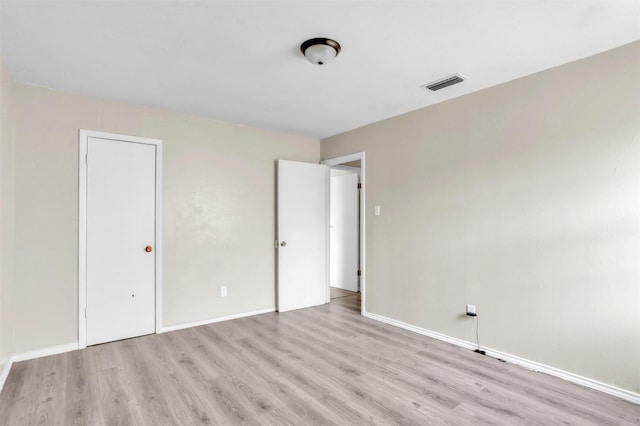 unfurnished bedroom with visible vents, baseboards, and wood finished floors