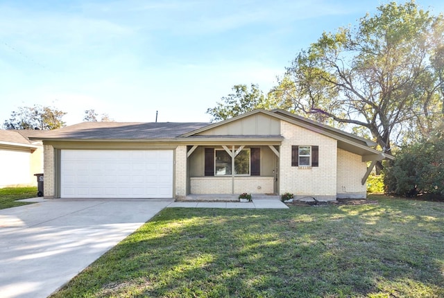 view of front of house featuring a front yard, an attached garage, brick siding, and driveway