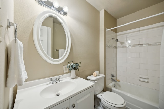 bathroom featuring vanity, toilet, a textured wall, and shower / bath combination