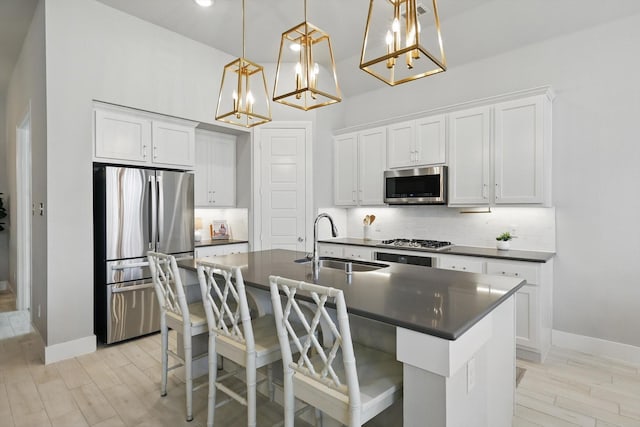 kitchen with a sink, tasteful backsplash, dark countertops, and appliances with stainless steel finishes