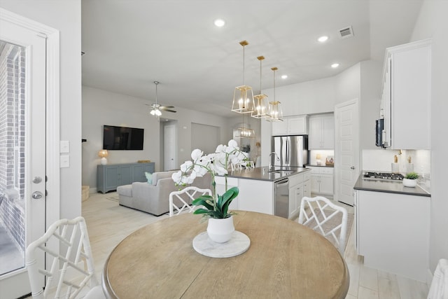 dining area with ceiling fan with notable chandelier, recessed lighting, and visible vents