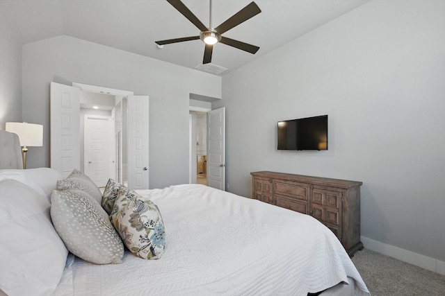 carpeted bedroom featuring lofted ceiling, connected bathroom, baseboards, and ceiling fan