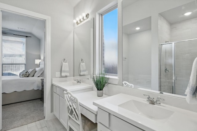 full bathroom featuring a shower stall, double vanity, ensuite bathroom, and a sink