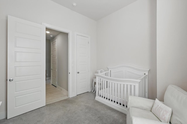 bedroom featuring a crib and carpet