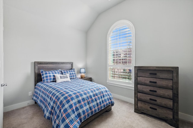 carpeted bedroom with baseboards and vaulted ceiling