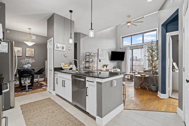 kitchen featuring a sink, dark countertops, light tile patterned flooring, and stainless steel appliances