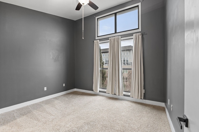 spare room featuring baseboards, carpet floors, and ceiling fan