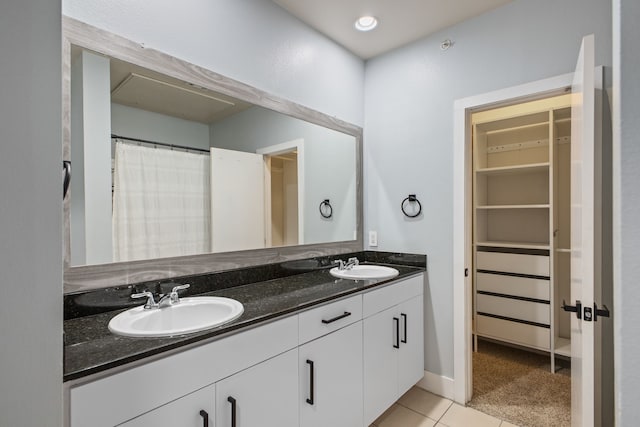 full bathroom featuring tile patterned flooring, double vanity, a spacious closet, and a sink