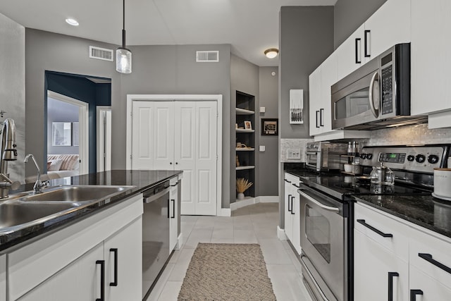 kitchen with a sink, visible vents, appliances with stainless steel finishes, and decorative light fixtures