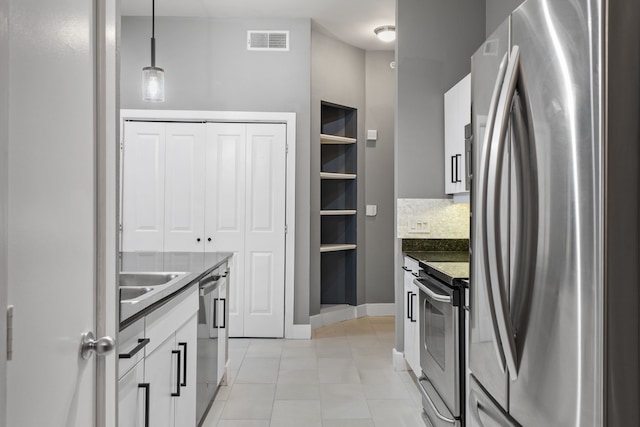 kitchen with stainless steel appliances, visible vents, white cabinets, and hanging light fixtures