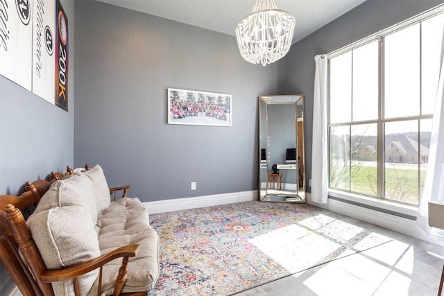 sitting room with a wealth of natural light, baseboards, and an inviting chandelier