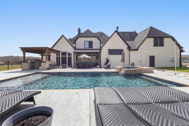 view of swimming pool with exterior kitchen, a patio area, a pool with connected hot tub, and outdoor dry bar