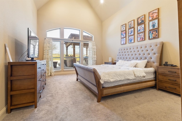 bedroom featuring light carpet, high vaulted ceiling, and access to exterior