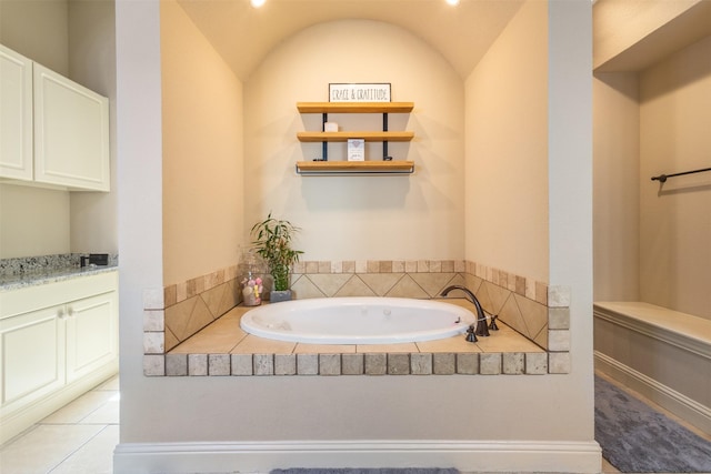 bathroom featuring tile patterned flooring, a garden tub, and vanity