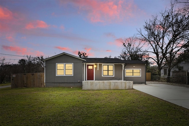 view of front of house with driveway, a front lawn, and fence