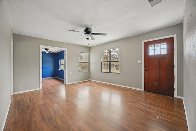 entrance foyer with plenty of natural light, baseboards, ceiling fan, and wood finished floors