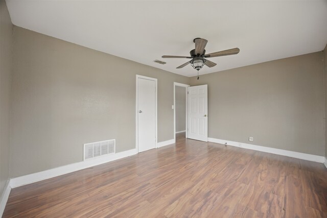 spare room featuring visible vents, baseboards, and wood finished floors