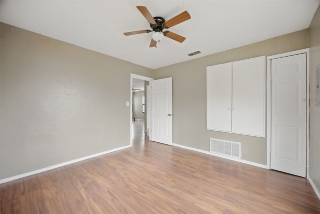 unfurnished bedroom with ceiling fan, wood finished floors, visible vents, and baseboards