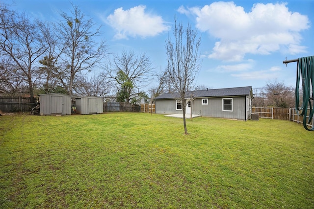 view of yard featuring an outbuilding, a shed, a patio area, and a fenced backyard