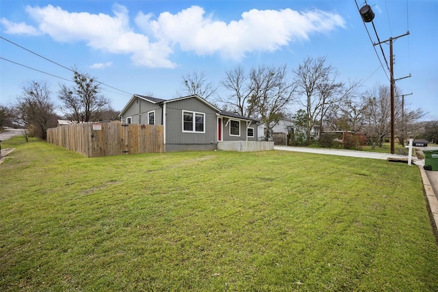 exterior space with driveway, a front lawn, and fence