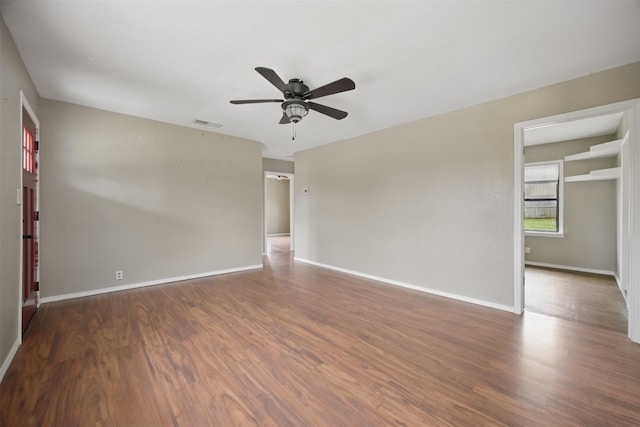 empty room with visible vents, baseboards, wood finished floors, and a ceiling fan