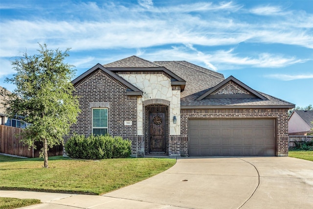 french country style house featuring brick siding, an attached garage, concrete driveway, and a front lawn