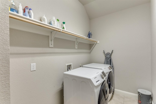 clothes washing area with light tile patterned floors, laundry area, independent washer and dryer, and baseboards