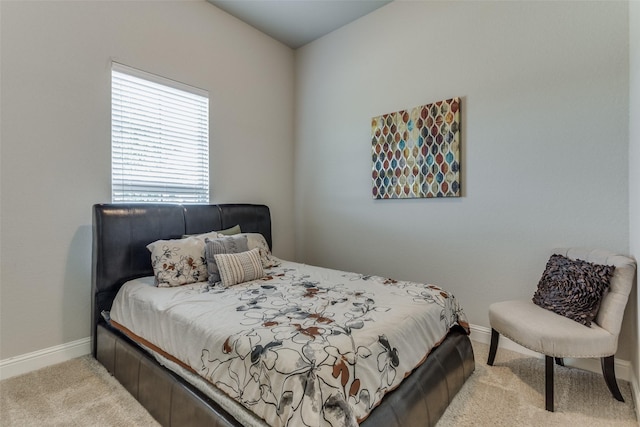 bedroom featuring light colored carpet and baseboards