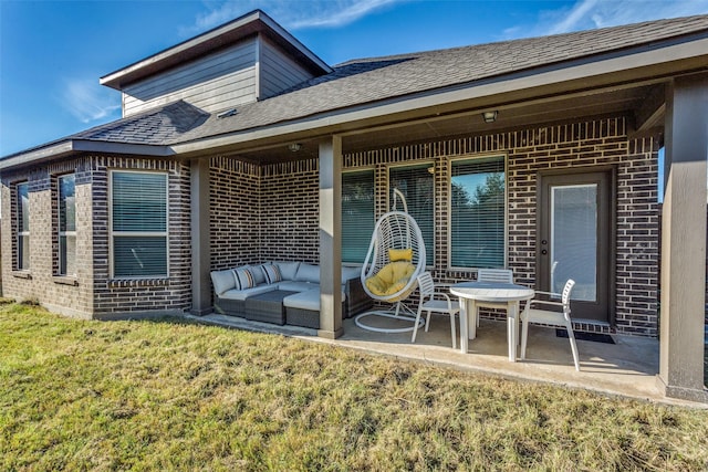 back of property featuring a yard, brick siding, outdoor lounge area, and a patio area