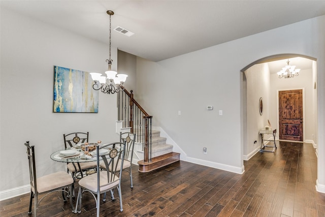 dining room featuring visible vents, stairway, arched walkways, a chandelier, and dark wood-style flooring