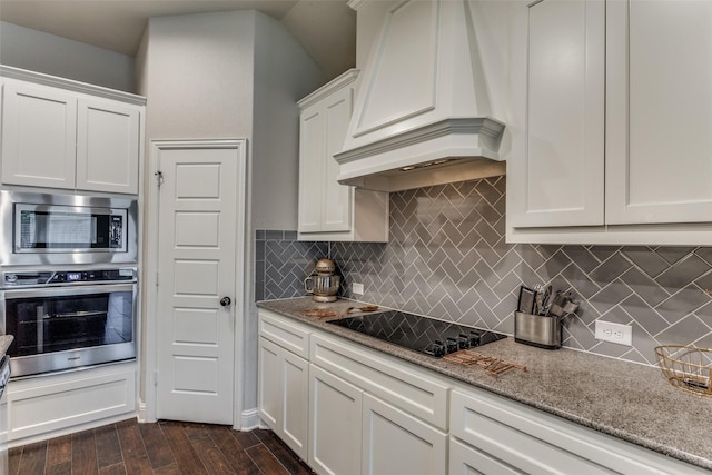 kitchen featuring light stone counters, stainless steel appliances, decorative backsplash, dark wood-type flooring, and white cabinetry