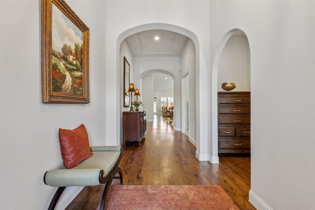 corridor with baseboards and dark wood-style flooring