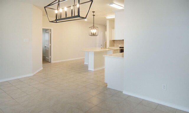 interior space with a notable chandelier, baseboards, and a sink