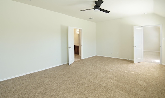 unfurnished bedroom with baseboards, ceiling fan, light colored carpet, vaulted ceiling, and ensuite bathroom