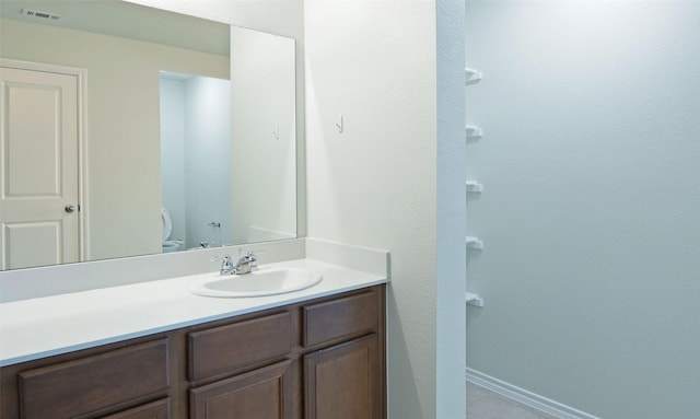 bathroom featuring visible vents, baseboards, toilet, and vanity