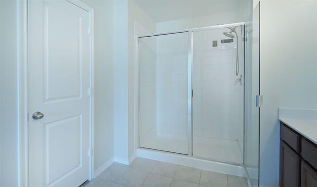 full bath featuring tile patterned floors, vanity, and a shower stall