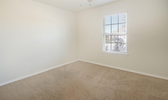 spare room with carpet flooring, ceiling fan, and baseboards