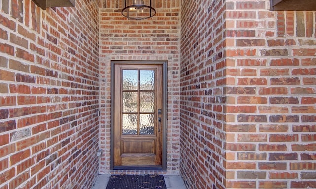 view of exterior entry with brick siding