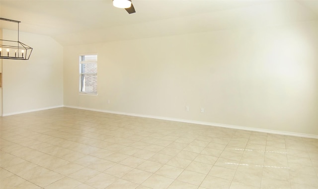 empty room with an inviting chandelier, vaulted ceiling, and baseboards